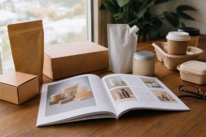 Katalog cetak terbuka di atas meja kayu dengan halaman produk tertata rapi